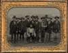 group of men, Doy seated at center in light colored jacket, men in dark colored jackets standing around him